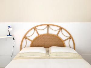 玛丽娜迪曼卡维萨Appartamento Patrizia的一张带木制床头板和两个枕头的床