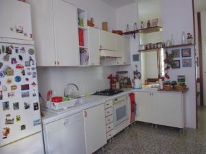 科莫伊尔普拉塔诺公寓的厨房配有白色橱柜和冰箱。