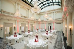 柏林罗马罗科·福尔蒂酒店的大房间设有白色的桌子和吊灯