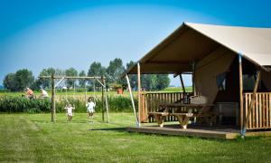 OostvleterenGlamping Aan de Vleterbeke的一群儿童在帐篷前跑