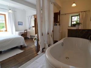 哈穆瓦尔Enchanting Cottage with Terrace Garden的一间带浴缸和床的浴室以及一间卧室