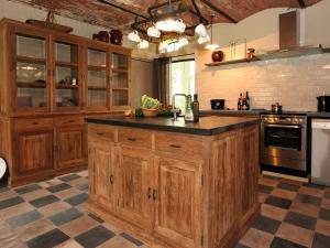 贝尔内姆Rural holiday home in former stables的厨房配有木制橱柜和台面