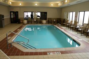 卡特湖倍斯特维斯特奥马哈机场酒店的酒店客房的大型游泳池配有桌椅