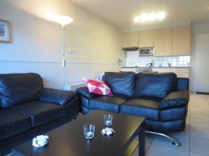 布列登Stylish Apartment in Bredene with Pool的客厅配有沙发和桌子
