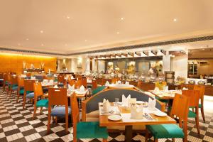 巴罗达Welcomhotel by ITC Hotels, Alkapuri, Vadodara的餐厅内带桌椅的用餐室