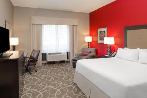 克拉马斯红杉国家公园智选假日酒店的酒店客房,设有白色的床和红色的墙壁
