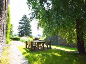 布永Wonderful Holiday Home in Noirefontaine的一张野餐桌和树下的两张长椅