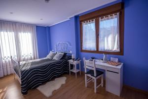 卡兰特萨蒙迪阿莱酒店的一间卧室设有蓝色的墙壁、一张床和一张书桌