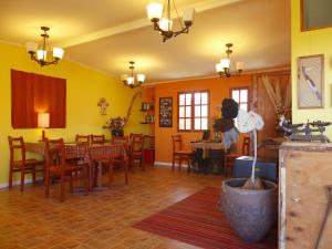 普特雷露台小屋旅馆的用餐室设有黄色的墙壁和桌椅