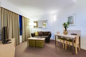 布里斯班Oakbridge Hotel & Apartments Brisbane的客厅配有沙发和桌子