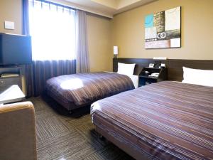海老名市神奈川意科麦茹特旅舍的酒店客房设有两张床和一台平面电视。