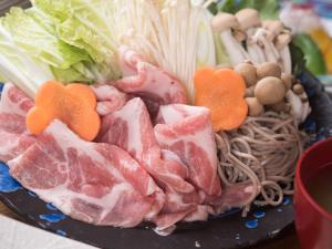都城市常盘庄日式旅馆的上面有肉和蔬菜的盘子