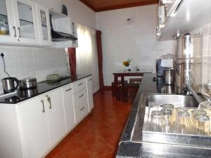 乌提伊里恩贾拉库达民宿的厨房配有白色橱柜和不锈钢盥洗盆