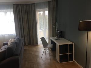 布拉索夫Kiem Premium Apartments的客厅配有沙发、桌子和椅子