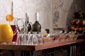 瓦莱塔The Coleridge Boutique Hotel In Valletta的桌子,上面放着眼镜和瓶装葡萄酒及食物