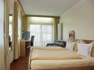 布尔Rebstock Kappelwindeck的酒店客房设有一张大床和一张书桌。
