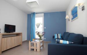 巴登Résidence Odalys Les Iles du Morbihan的蓝色的客厅配有蓝色的沙发和电视