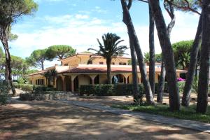 卡沃Residence Villa La Pineta的前面有棕榈树的房子