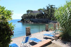 卡沃Residence Villa La Pineta的一组椅子坐在海边