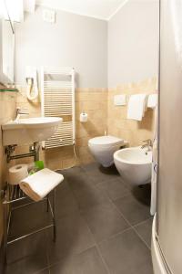 里奥马哲雷兰科拉酒店的浴室配有2个盥洗盆、卫生间和浴缸。
