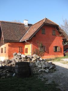 韦因地区拉奇Ferienwohnungen Sonnenberg的一座红色的大房子,前面有石墙
