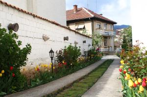 佩奇Sarac Hostel的鲜花和人行道的花园