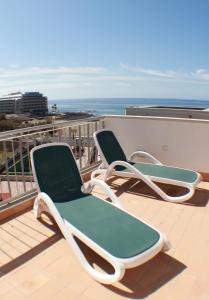 厄尔梅达诺Alquilaencanarias-Medano Los Martines beachfront A的阳台配有两把椅子,背靠大海
