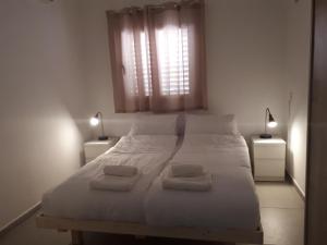 Beʼer OraPina BaMidbar的卧室配有白色的床和2条毛巾