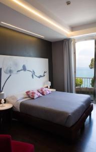代森扎诺-德尔加达维托里奥酒店的一间卧室设有一张大床和大窗户