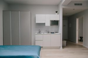 特拉尼Trani Rent Rooms的白色的厨房配有床和水槽