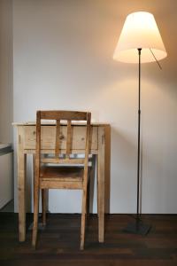 莱克斯波斯塔维格利亚酒店的一张带椅子和台灯的木桌