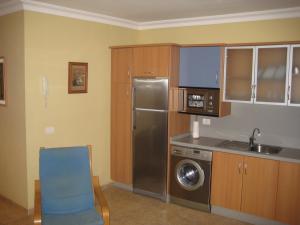 圣克鲁斯-德特内里费S/C de Tenerife, apartamento 1 dormitorio的厨房配有不锈钢冰箱和蓝椅
