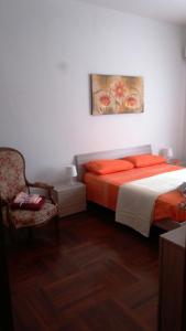 塔兰托Etra的一间卧室配有带橙色枕头和椅子的床