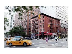 纽约卡尔顿埃姆斯酒店的一条黄色出租车在城市街道上,有建筑