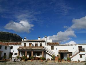 佩里那Belvilla by OYO Cortijo las Monjas的一座白色的大建筑,背后是蓝天