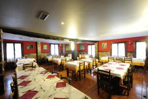 莱萨卡如洛尔贝里奥酒店的一间设有桌椅和红色墙壁的餐厅