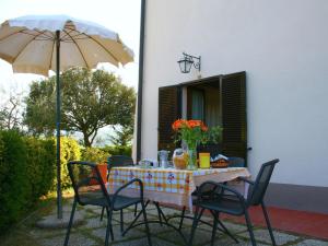ContignanoSpacious Farmhouse in Pienza with Swimming Pool的桌椅、桌子和雨伞