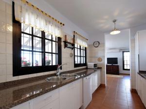 阿尔加罗沃Belvilla by OYO Casa Loli的带水槽的厨房和2扇窗户