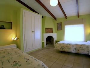隆达卡萨坎德拉度假屋的一间卧室设有两张床和一个壁炉