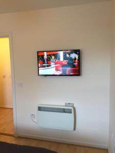 福里斯6 Varis Apartments的挂在白色墙壁上的平面电视