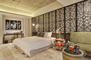 马六甲马六甲泰姆兹酒店的一间卧室配有一张床、一张桌子和一张沙发