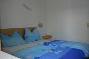 圣卡尼兹Bungalows Karin的一张带蓝色枕头和蓝色毯子的床