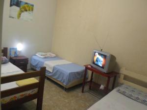 帕尔马斯Hotel Palmas Tocantins的小房间设有两张床和电视