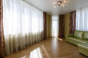 喀山Nataliya's flat apartments Shcherbakovskiy pereulok 7的客厅配有窗帘和绿色沙发