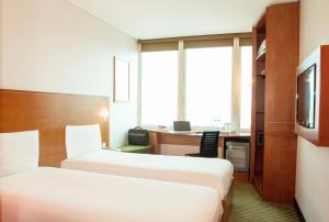 科威特ibis Kuwait Salmiya的酒店客房配有两张床和一张书桌