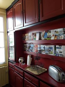 日安Le Repos du Marinier的厨房配有红色橱柜和带烤面包机的台面