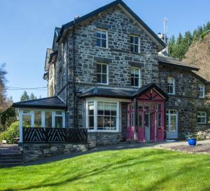 贝图瑟科伊德Summerhill Guest House的石屋,带粉红色门和院子