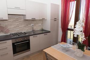 布鲁法Appartamenti Brufa Civico 13/17的厨房配有白色橱柜和炉灶烤箱。
