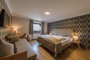 萨尔察赫河畔戈灵豪斯福酒店的一间卧室配有一张大床和一张沙发