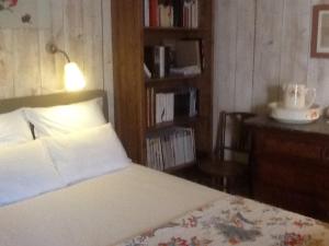 特雷莫拉Gîte Les Truffières的一间卧室配有一张带台灯和书架的床